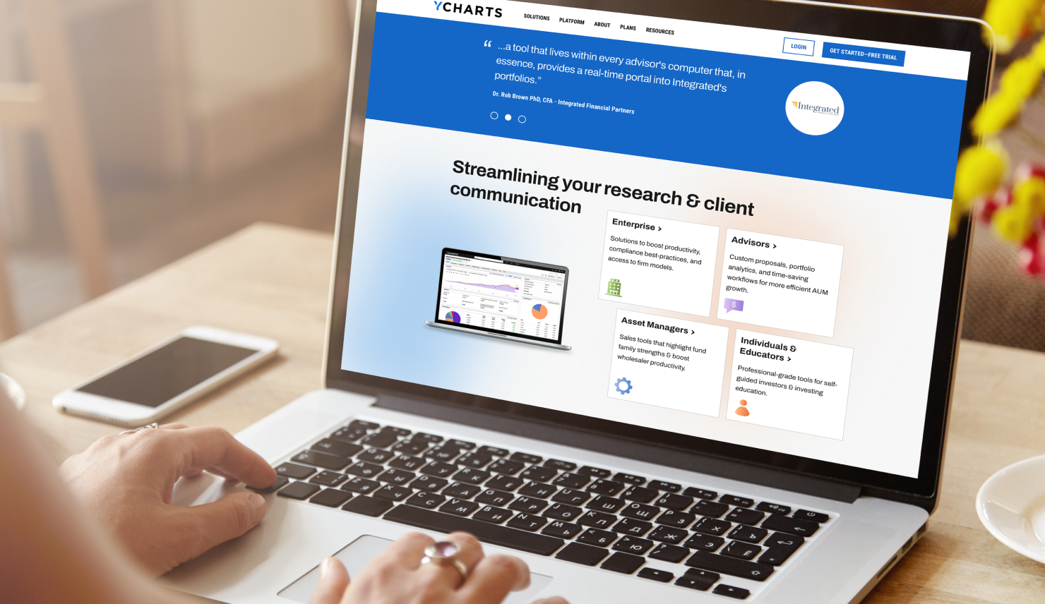 Woman's hands on a laptop showing the website's homepage design 